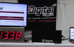 DC-Digital, Network Clock, Time of Day, Network Browser, RJ-45 Connection, Ethernet Connection, Portable Laptop, TV Screen, Flushed, DC-25, White Table, DC-Digital Logo