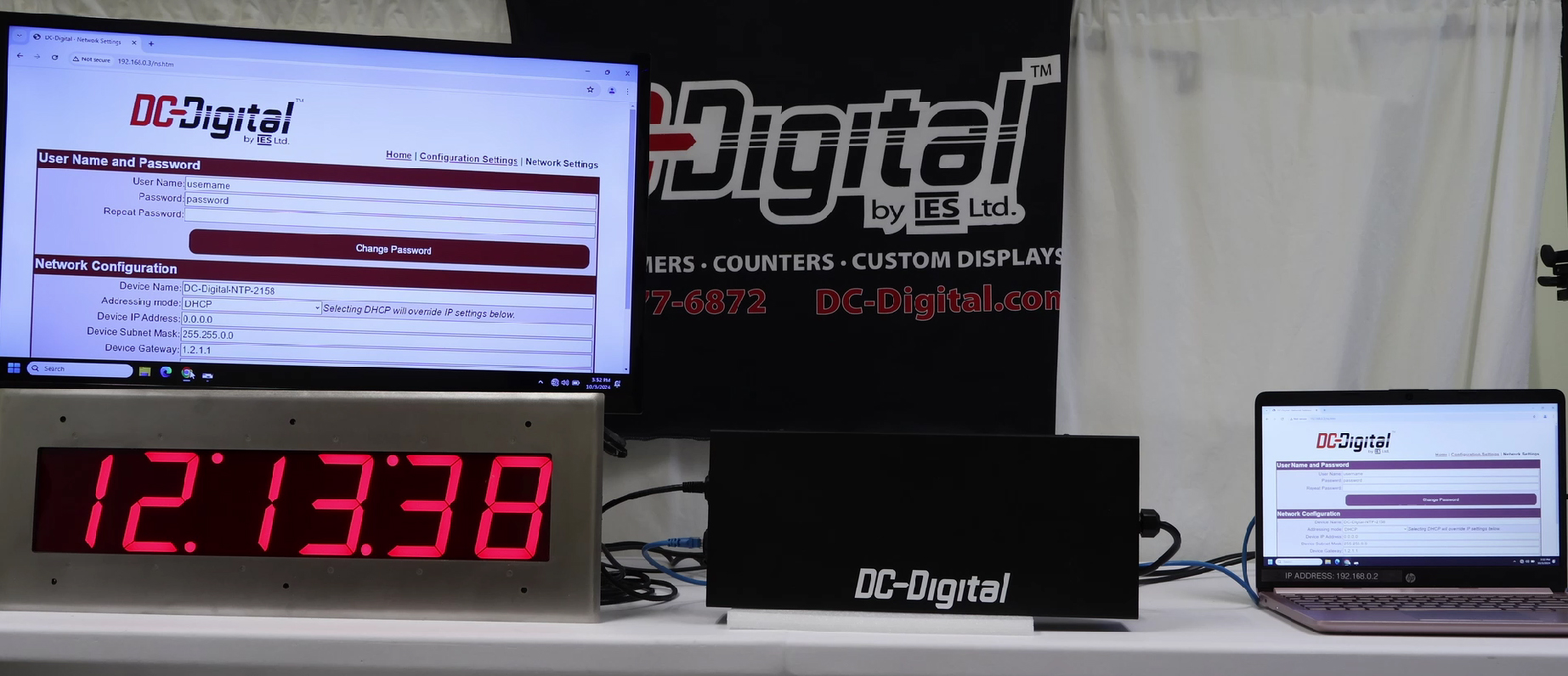 DC-Digital, Network Clock, Time of Day, Network Browser, RJ-45 Connection, Ethernet Connection, Portable Laptop, TV Screen, Flushed, DC-25, White Table, DC-Digital Logo